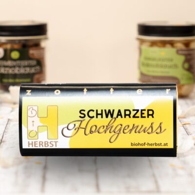 Schokolade mit fermentiertem Knoblauch im Vordergrund, Spezialitäten vom Biohof Herbst im Hintergrund.